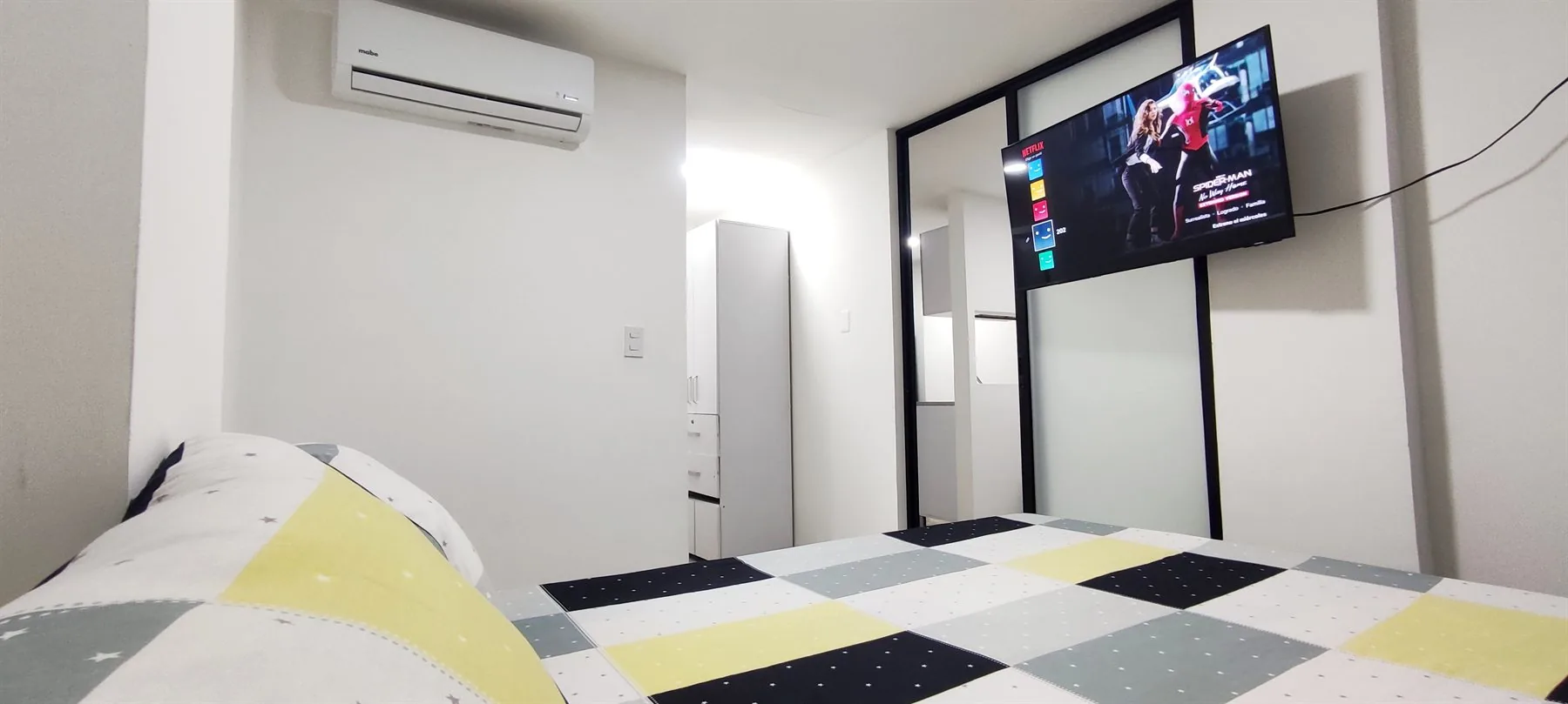 Cama y zona de TV del Apartaestudio 201